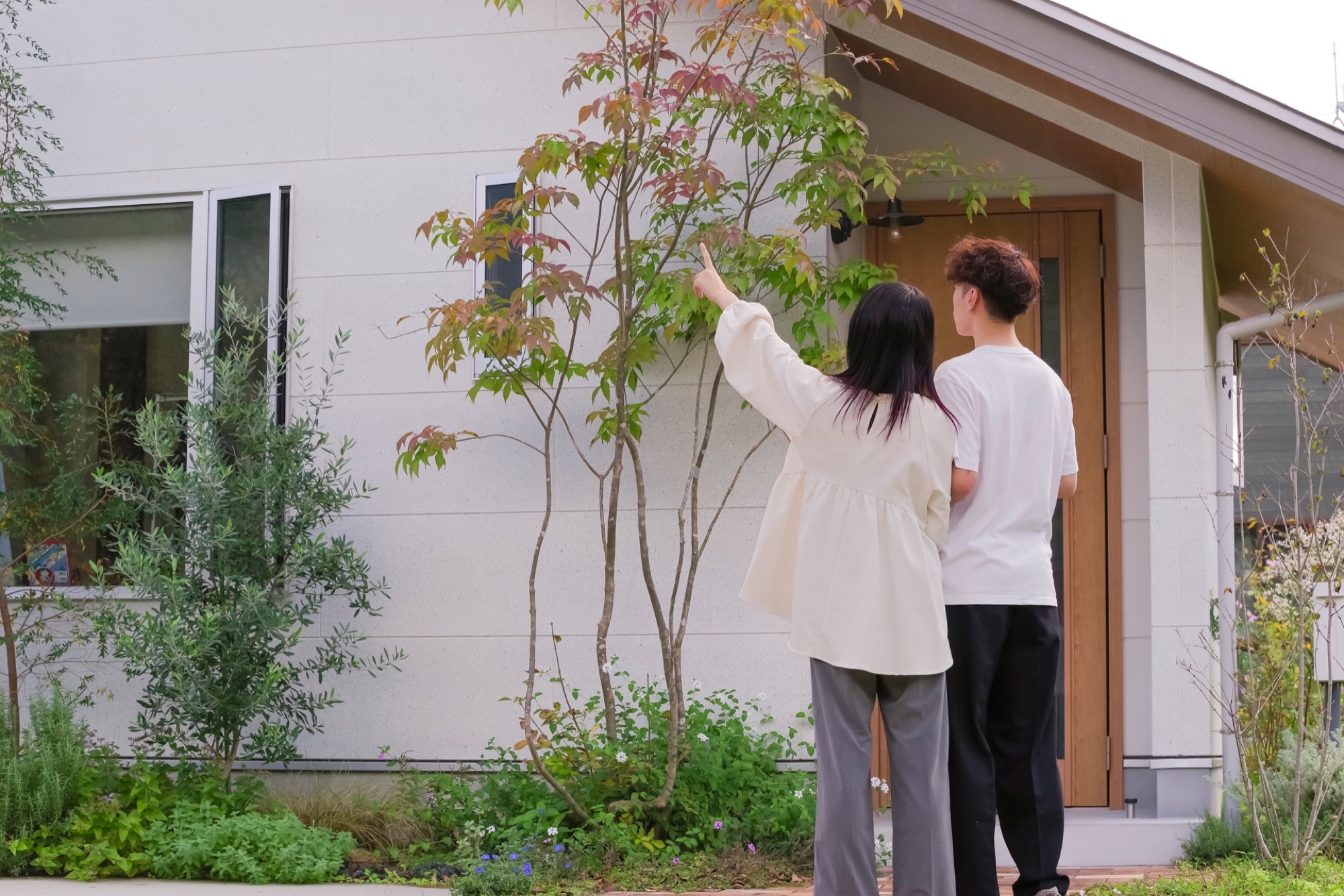 完成した住宅の外観に立つ夫婦